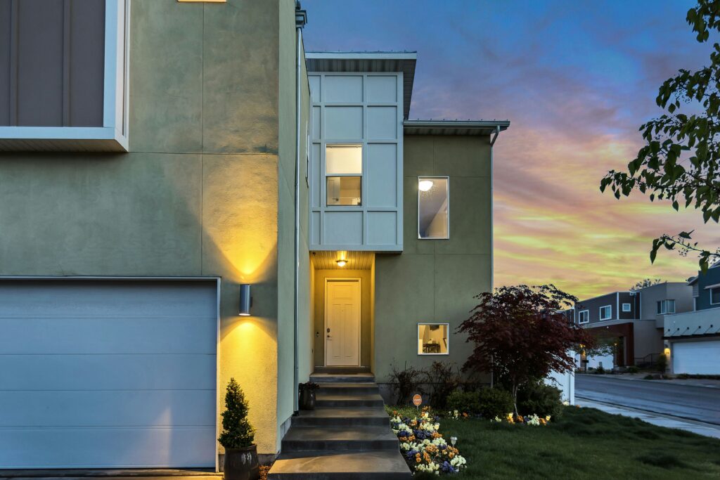 Modern Luxury Home Exterior With Illuminated Entryway And Contemporary Architecture In Suburban Neighborhood